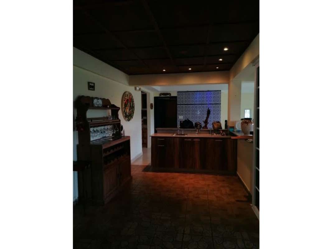 Country kitchen with dark wood cabinets, island, decorative tiles Cerro Azul Panama