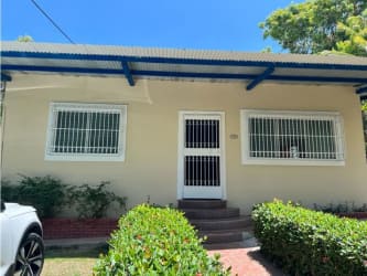 Single story home with metal security bars and lush shrubs in Punta Barco beach property