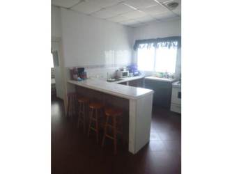 Kitchen with window, white backsplash, bar stools at Punta Barco beach house