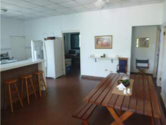 Wooden dining table, bar counter, ceiling fan in beach house Punta Barco