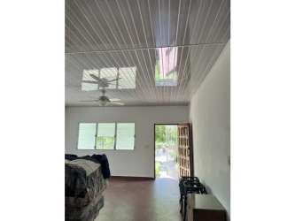 Minimalist bedroom bright with white panel ceiling, natural light, fan at beach house Punta Barco