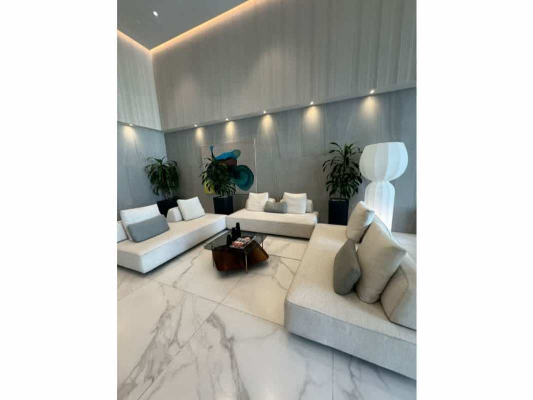 Modern lobby with marble floors high ceiling seating area at PH Costanera Panama City