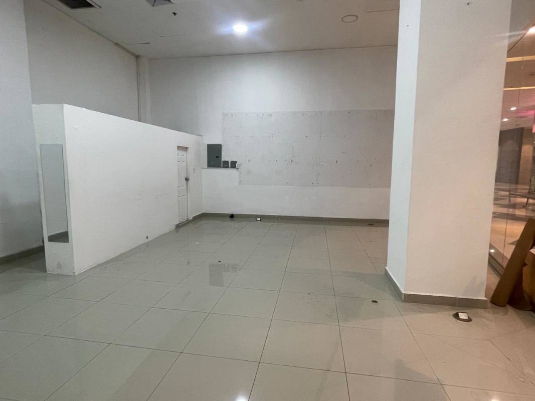 Interior of empty commercial retail unit with white walls, glass storefront, tiled floor at Dorado Mall Panama