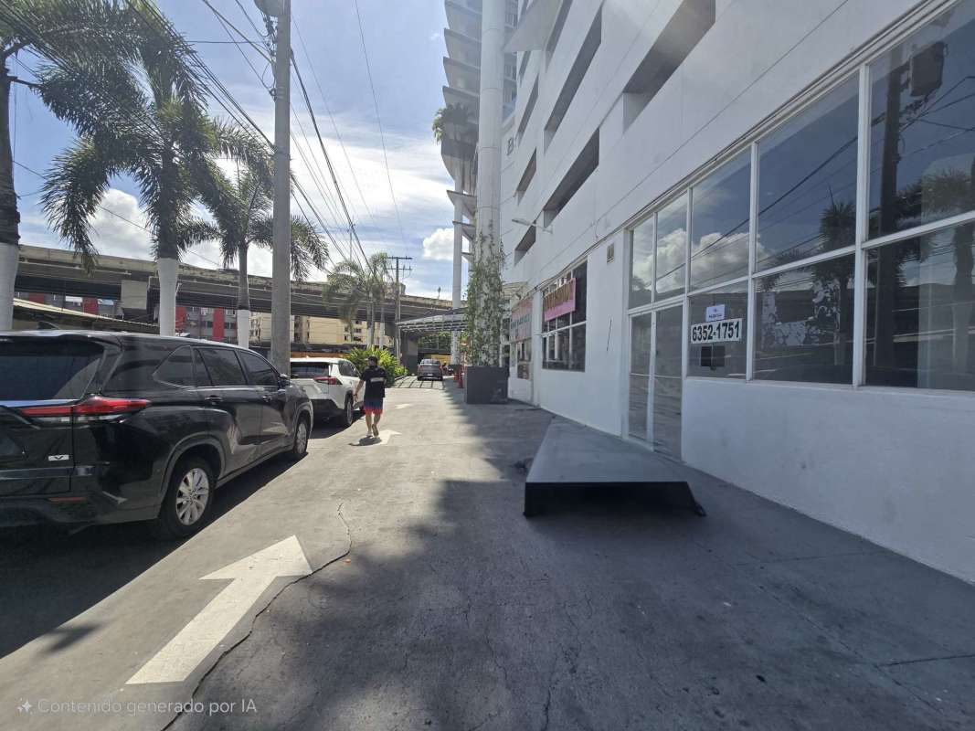 Commercial building exterior with large glass windows, parking, palm trees at Bay View Tower Panama City
