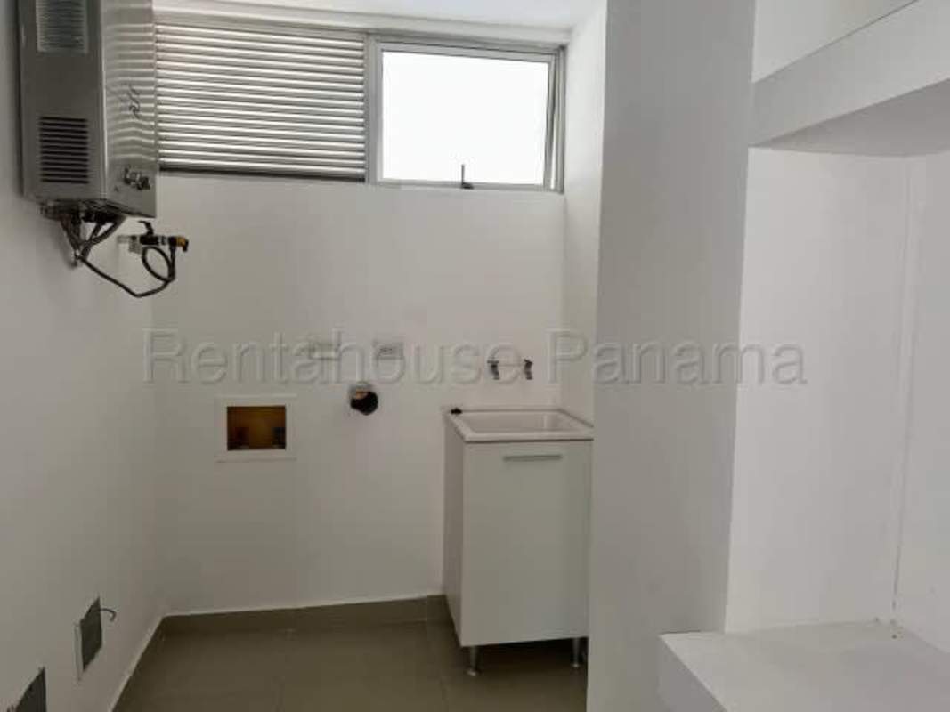 Modern kitchen with island, beige cabinets and ample lighting in Juan Díaz residence