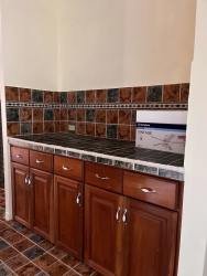 Kitchen with wooden cabinetry and ceramic countertops Altos del María mountain home Panama