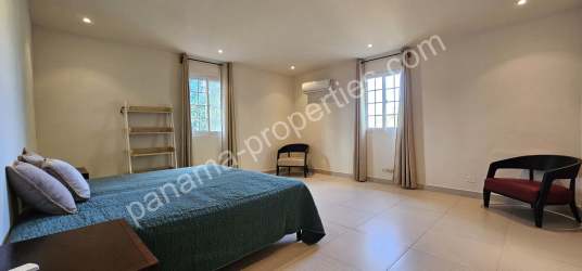 Bright minimalist bedroom with ceramic tile floors, neutral tones, large window Pedasi Panama
