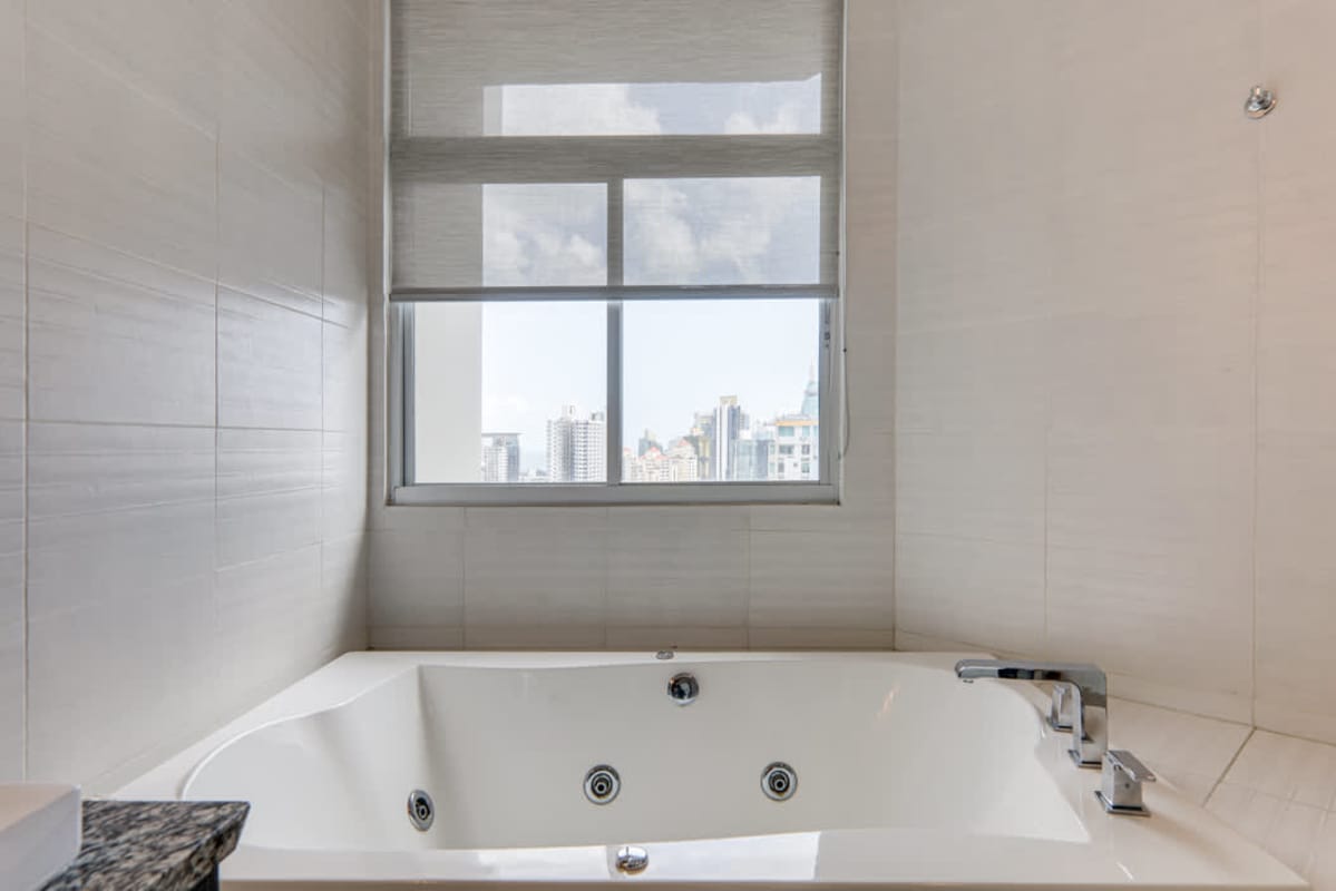 Modern bathroom with jacuzzi bathtub city skyline view in Junior Penthouse Luxor Tower Panama