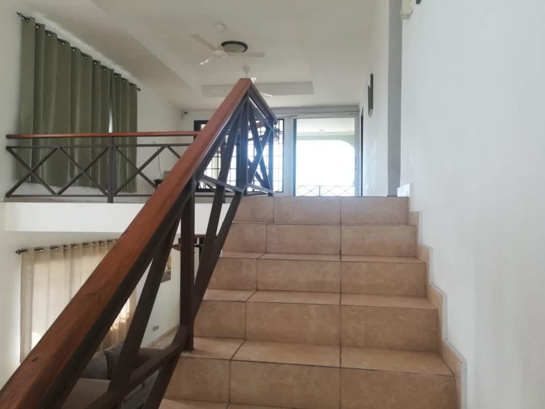 Open plan living dining room with natural light fans and staircase in Brisas del Golf Panama