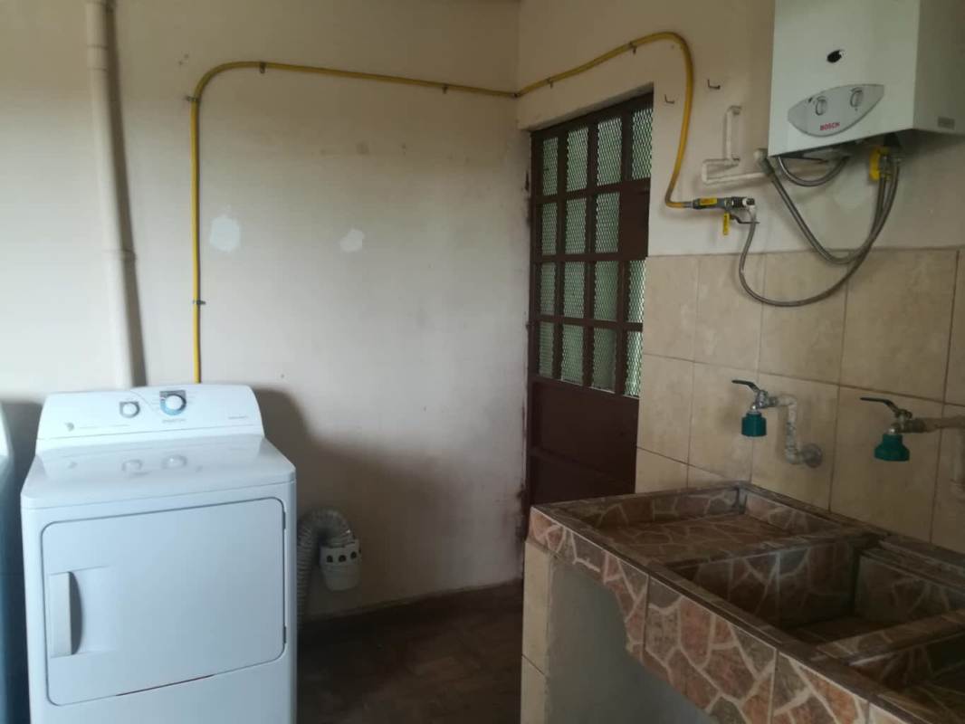 Laundry with washer, water heater, double sink, tiled walls Brisas del Golf Panama