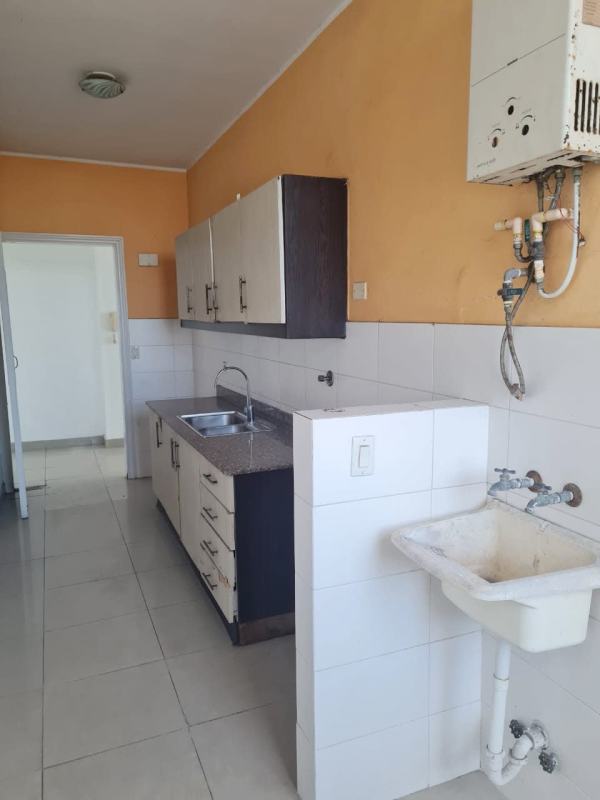 Galley kitchen with granite counters, cabinets, double sink and bright window in PH Latorraca Panama City