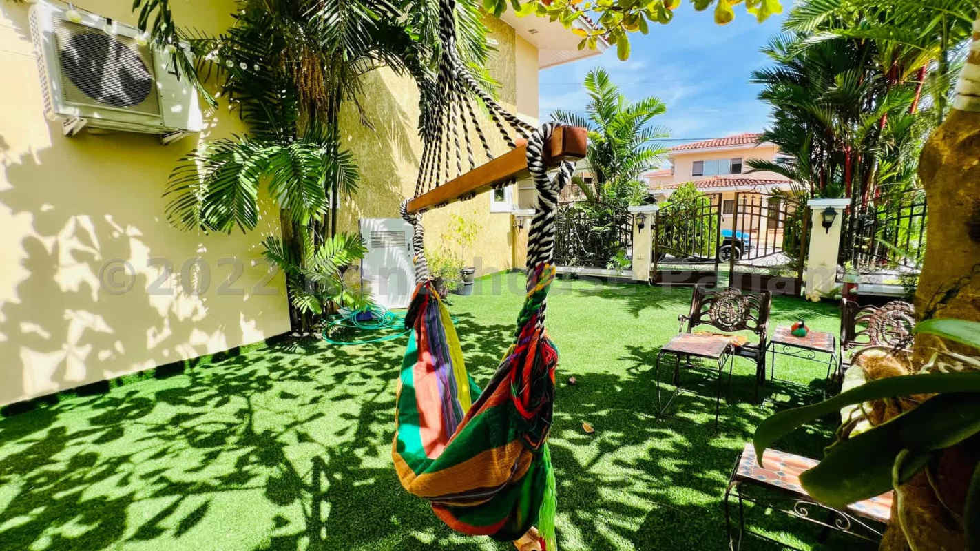 Tropical backyard with swimming pool, palms, grass lawn and patio Villa Alta Panama