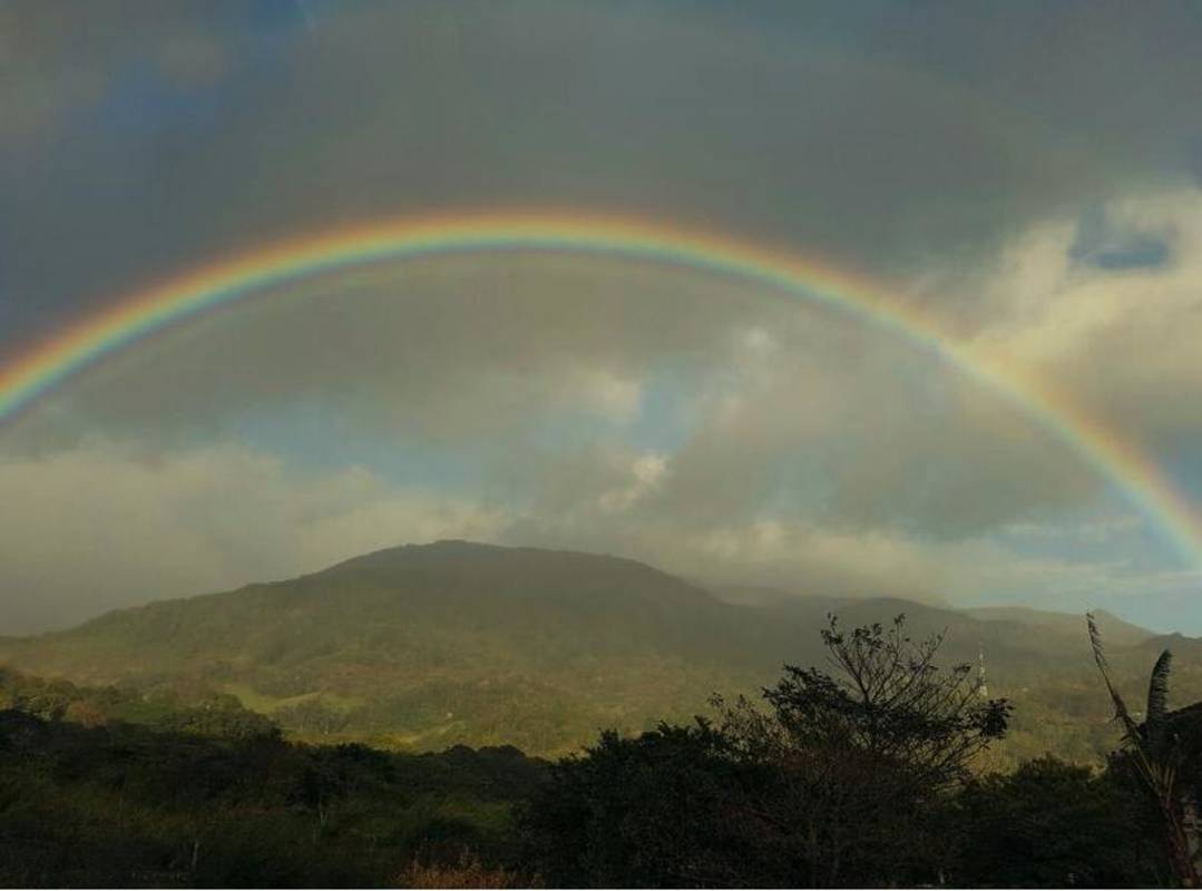Beautiful rainbow arch over mountainous terrain lush vegetation Paso Blanco Pacora