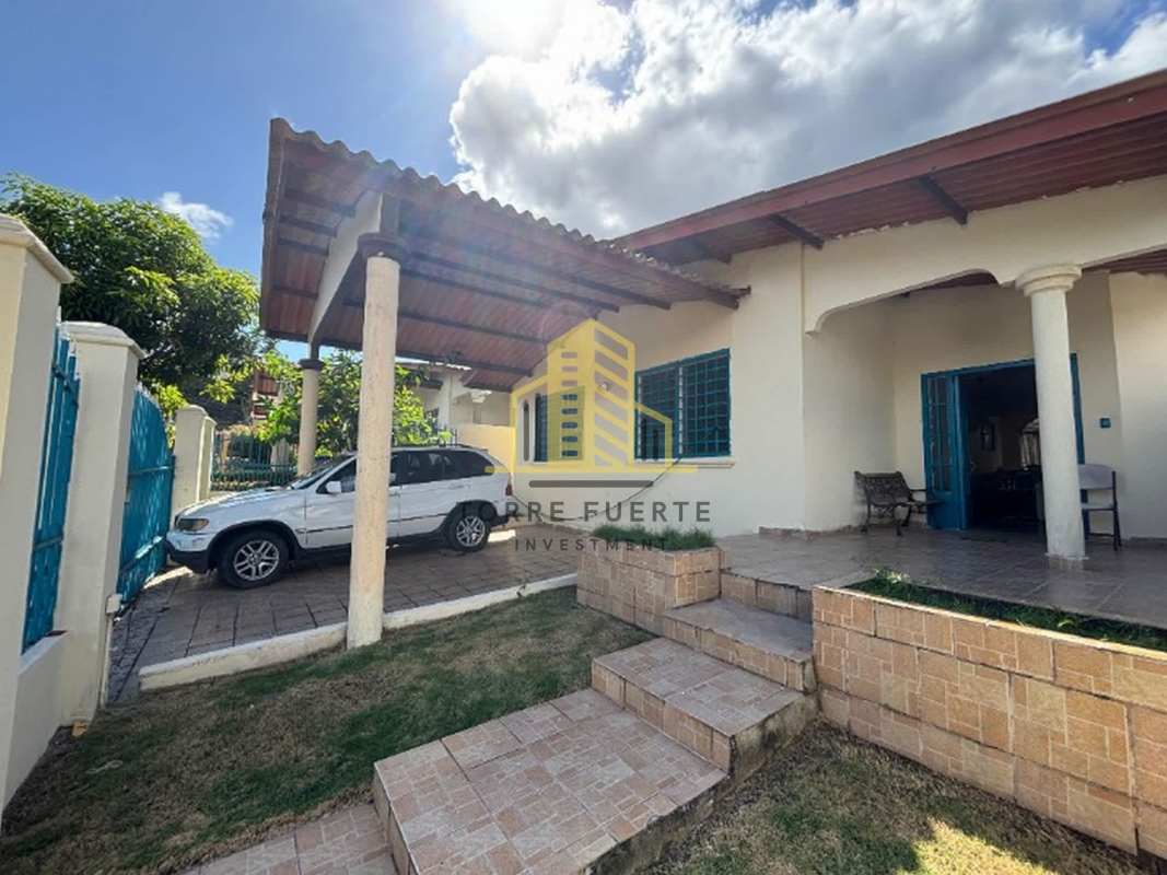 House exterior with covered porch, carport and blue window bars in Brisas del Golf Panama