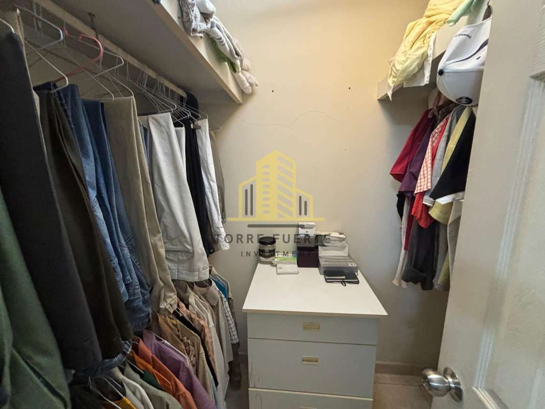 Blue entry gate, tiled walkway and clay roof of suburban house Brisas del Golf Panama