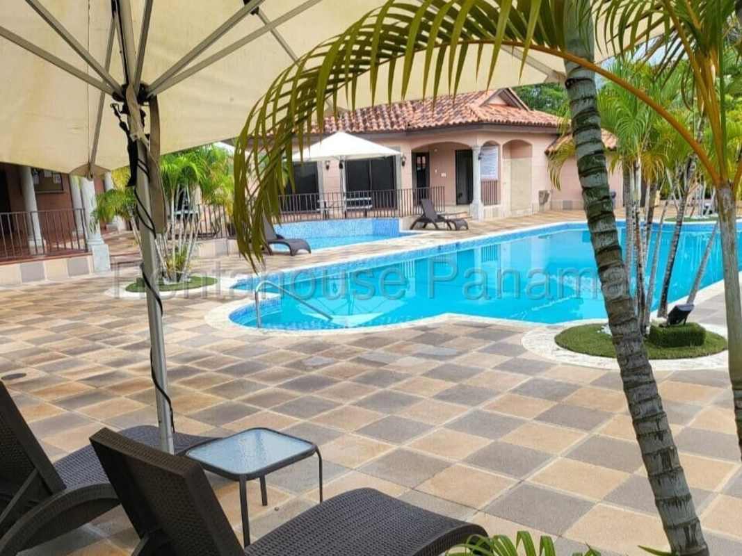 Large outdoor swimming pool with tropical gardens in Residencial Versalles Costa Sur Panama