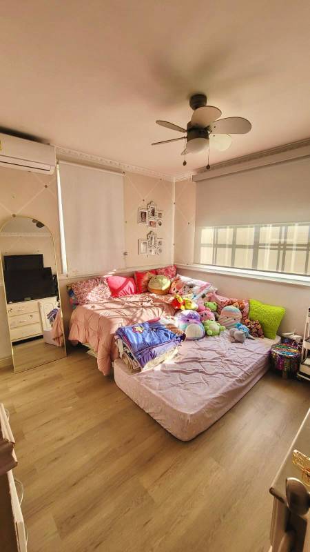 Light pink bedroom with colorful decor ceiling fan and wood floors in Crystal Springs Panama