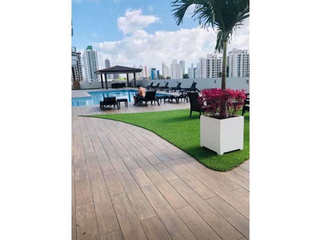 Rooftop pool with seating, palm trees and city skyline backdrop in PH Torre de Castilla Panama