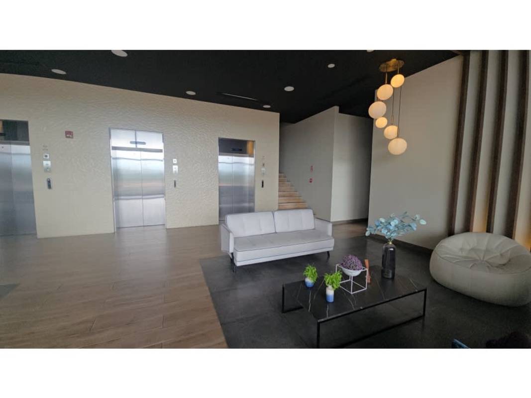 Double-height modern lobby with reception at PH Condado Country Heights in Panama City