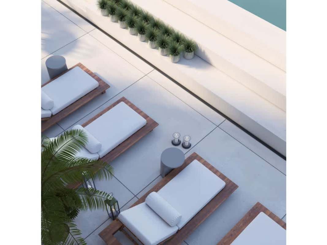 Minimalist outdoor poolside lounge with sun beds at Kyte Condos Panama