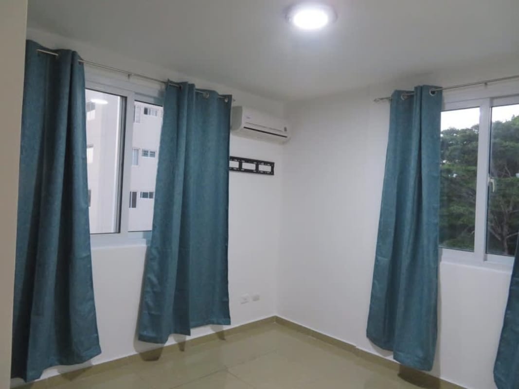 Bedroom with tile flooring blue curtains closet PH Urbis Ricardo Alfaro Panama