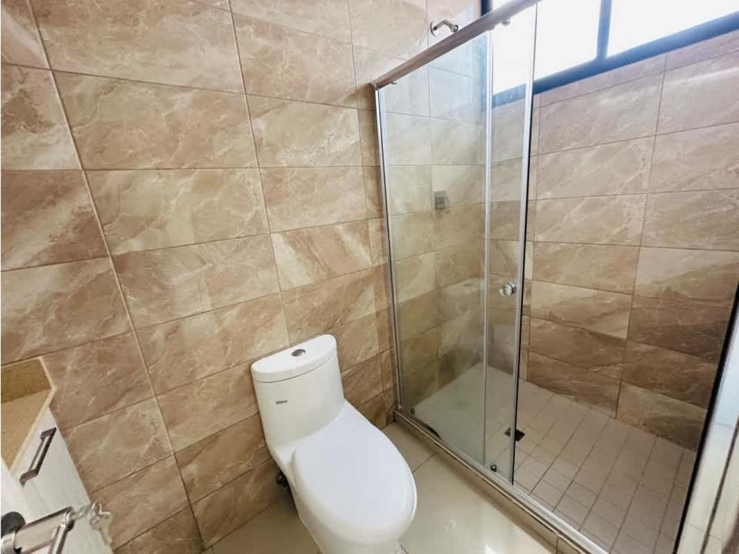 Modern bathroom with glass shower enclosure, beige tiles and sleek fixtures at PH Balboa Bay Panama