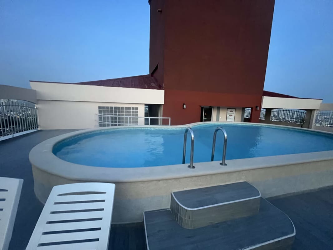 Rooftop swimming pool with lounge chairs sunset view at PH Villa Nuova Panama City
