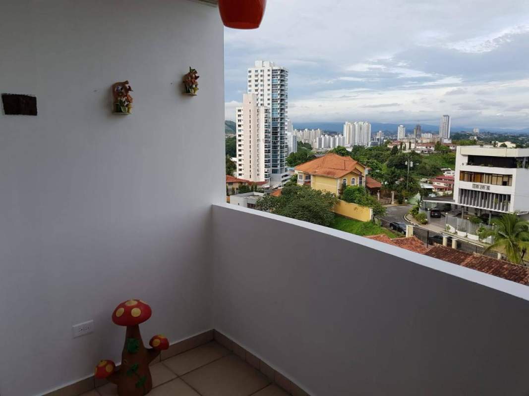 Balcony with decorative wall planters, mushroom sculpture, cityscape view at PH Villa Nuova Panama