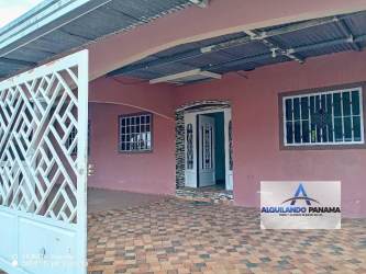 Traditional home backyard area with porch, barred windows, pink walls in David Panama