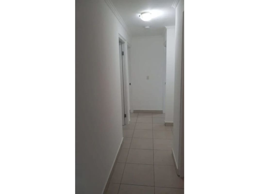 Well-lit hallway with tiled floors white walls in Las Palmeras Panama City