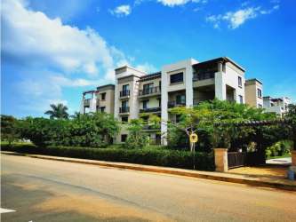 Living area with large windows opening to balcony and mountain views in PH River Valley Panama Pacifico apartment