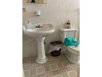 Terracotta-tiled covered terrace with sectional seating and brick columns in Coronado rented house