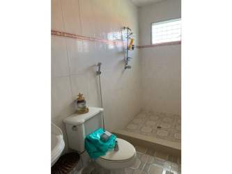 Rustic outdoor kitchen with brick BBQ, hood and blue backsplash in garden Coronado Panama