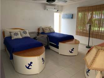 Rustic kitchen with terracotta floors, large window, blue tile backsplash, wood cabinets Coronado rental