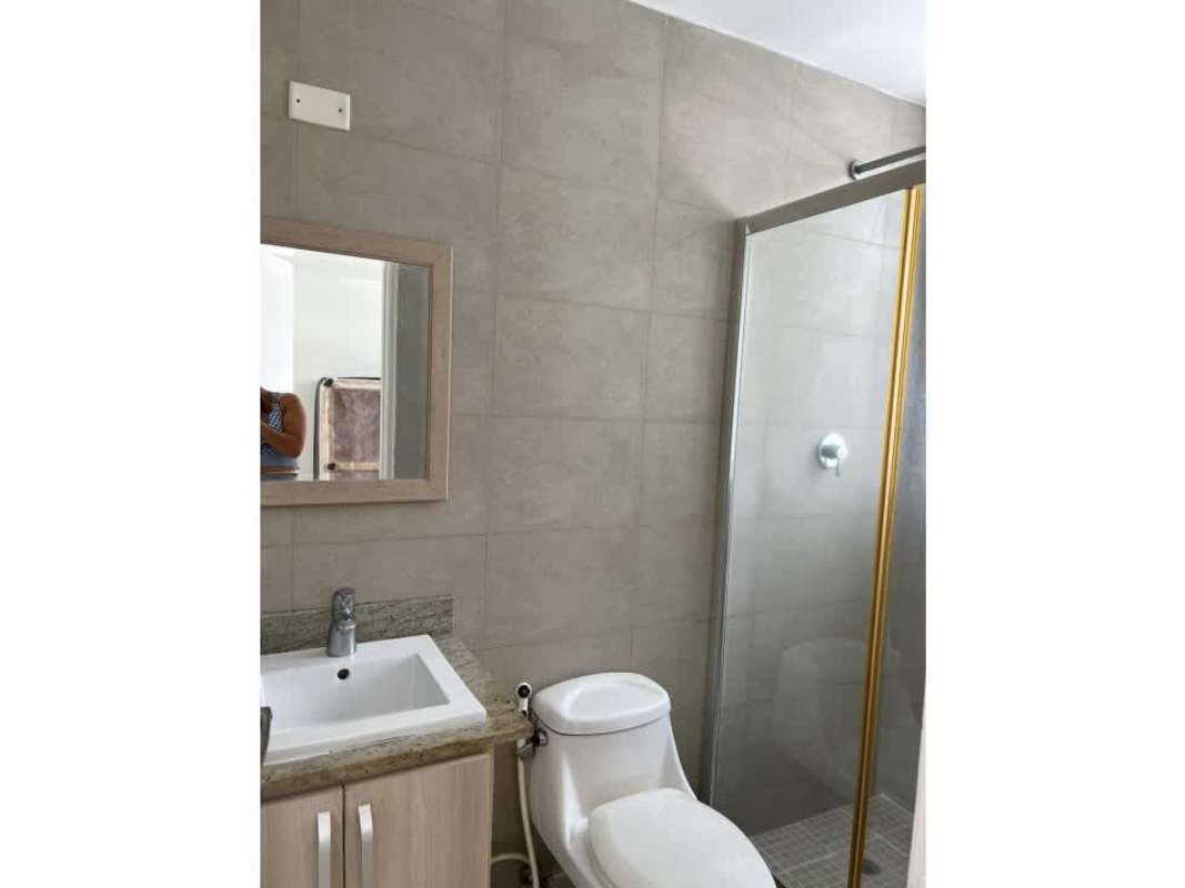 Bathroom with light wood cabinet and glass enclosed shower PH Rokas Panama