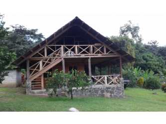 Rustic cabin with porch and stairs surrounded by greenery Cerro Azul farm