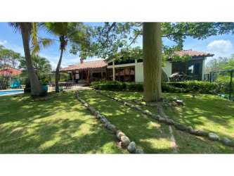 Large tropical lawn with mature landscaping and stone paths in Coronado Golf Estate Panama