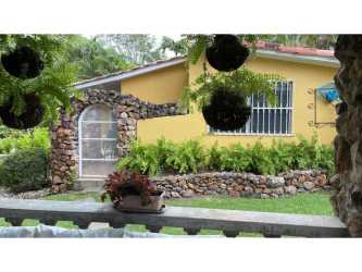 Rustic covered patio with arches, stone bar, shaded seating at Coronado Golf villa Panama