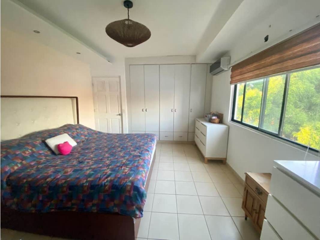 Large bedroom with colorful bedspread, white closets, window PH Saramel Parque Lefevre