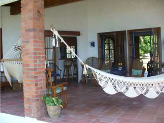 Covered patio terrace facing the ocean with seating at Coronado beachfront home