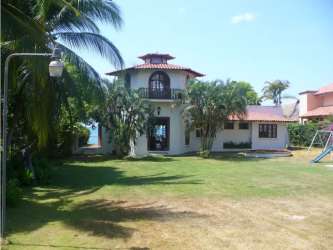 Open-plan living and dining room with tropical style at beachfront house in Coronado Panama
