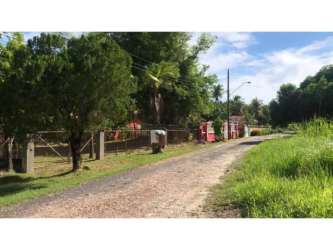 Entrance gate and dirt road fenced tropical lot near Coronado Beach Panama