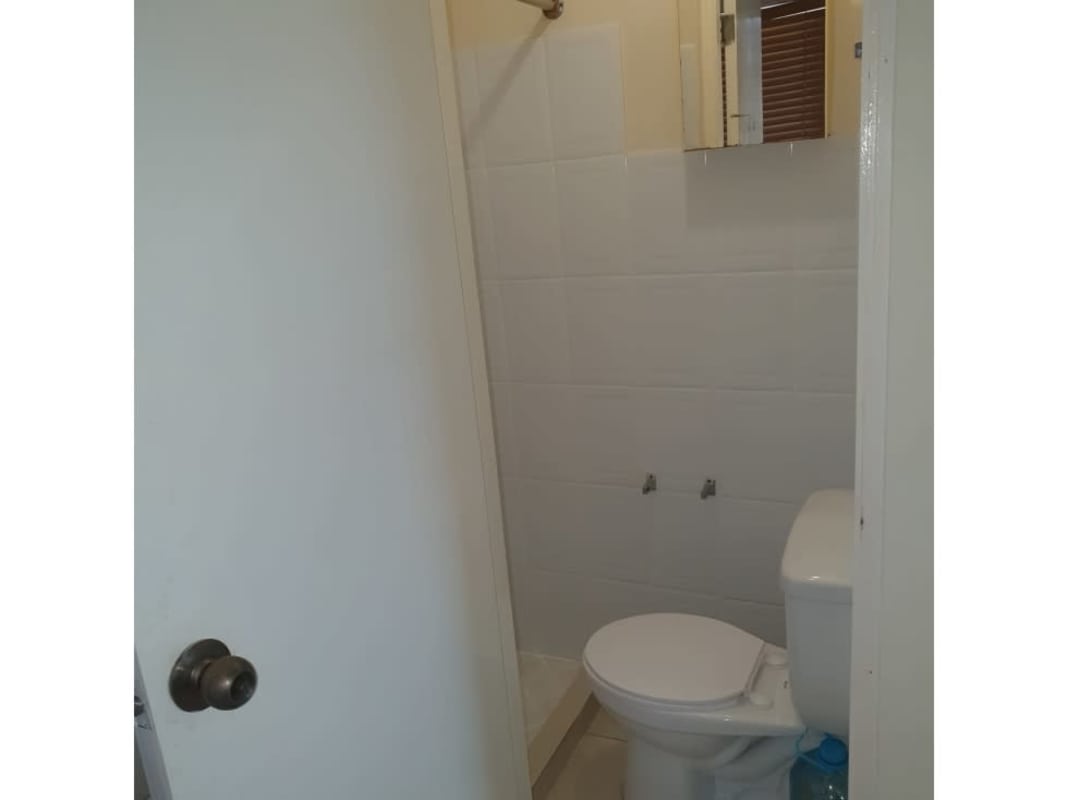 Simple bathroom with tiled shower area curtain rod Panama apartment