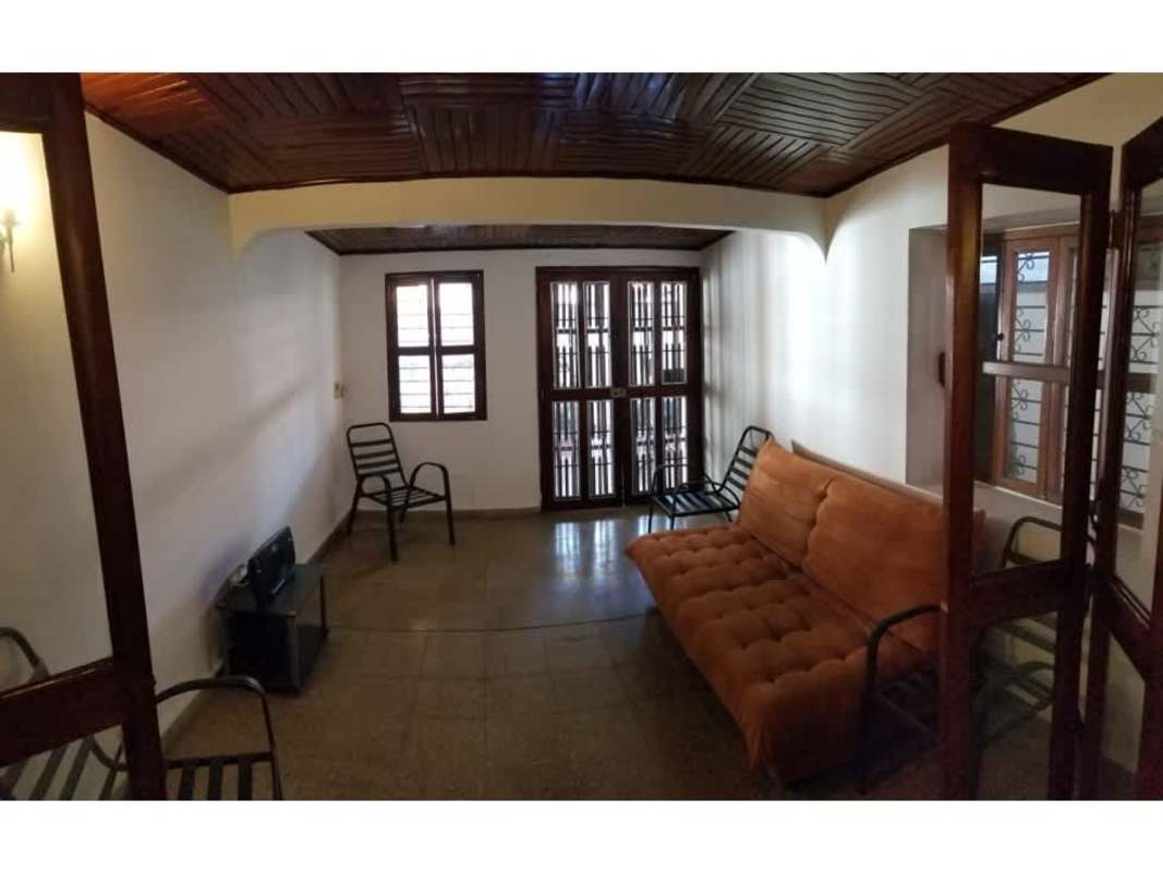 Living room with wood ceiling, orange sofa, and metal chairs house for sale Panama
