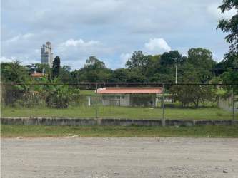 Empty flat lot with grass and fencing near residential homes Coronado Panama
