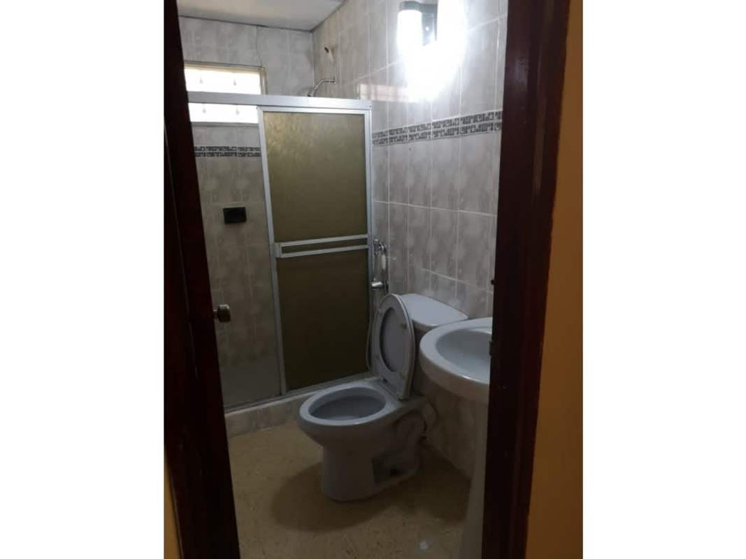 Bathroom with tiled walls, enclosed shower, sink and toilet in commercial-residential house Panama