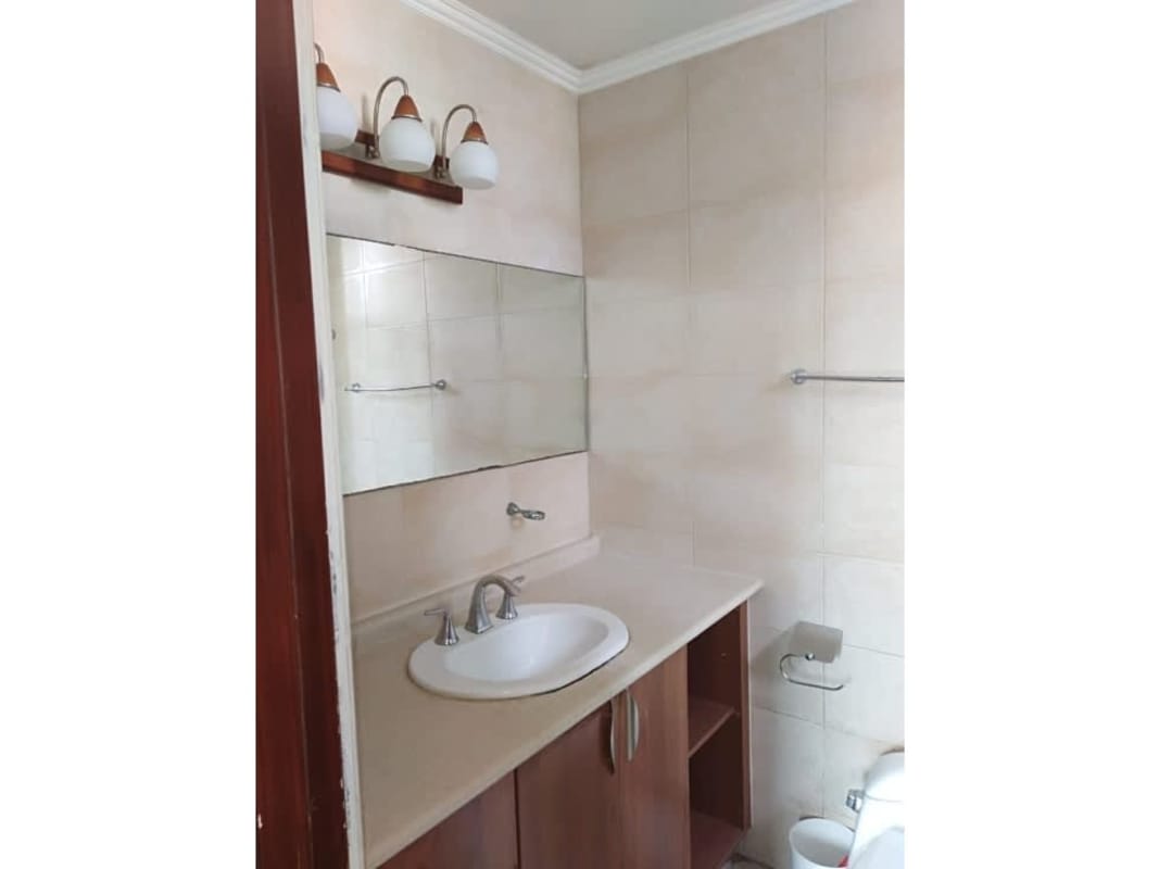 Bathroom with beige tiles, wooden vanity, large mirror PH Onyx Towers El Cangrejo Panama City