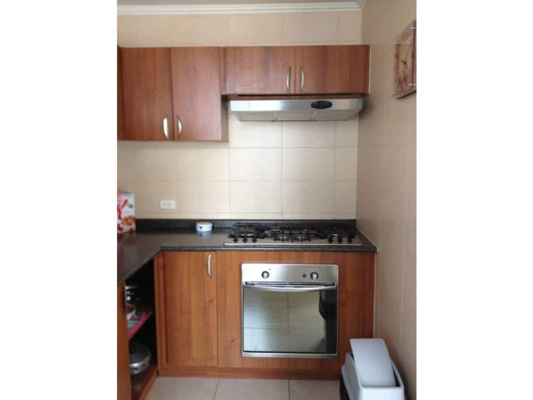 Kitchen with granite countertop, stove, oven, wooden cabinets PH Onyx Towers El Cangrejo Panama City