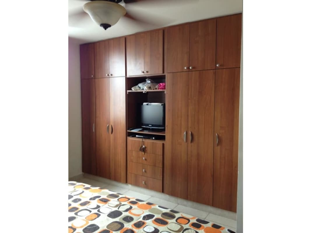 Bedroom space with built-in wooden closets and fan in PH Onyx Towers Panama City