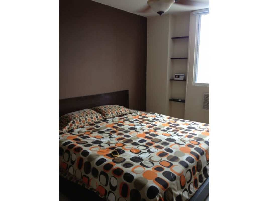 Bedroom interior with large wood wardrobe, fan and colorful bedding in PH Onyx Towers Panama